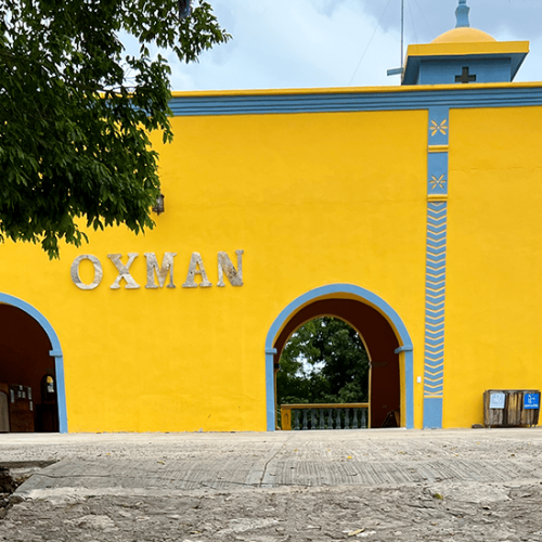  בניין בצבע צהוב שכתוב עליו אוקסמן